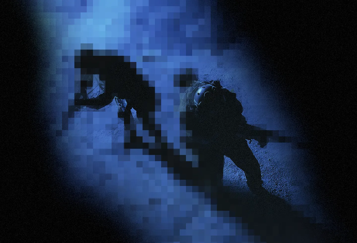 Overhead view of two soldiers in tactical gear moving cautiously on a dimly lit ground.